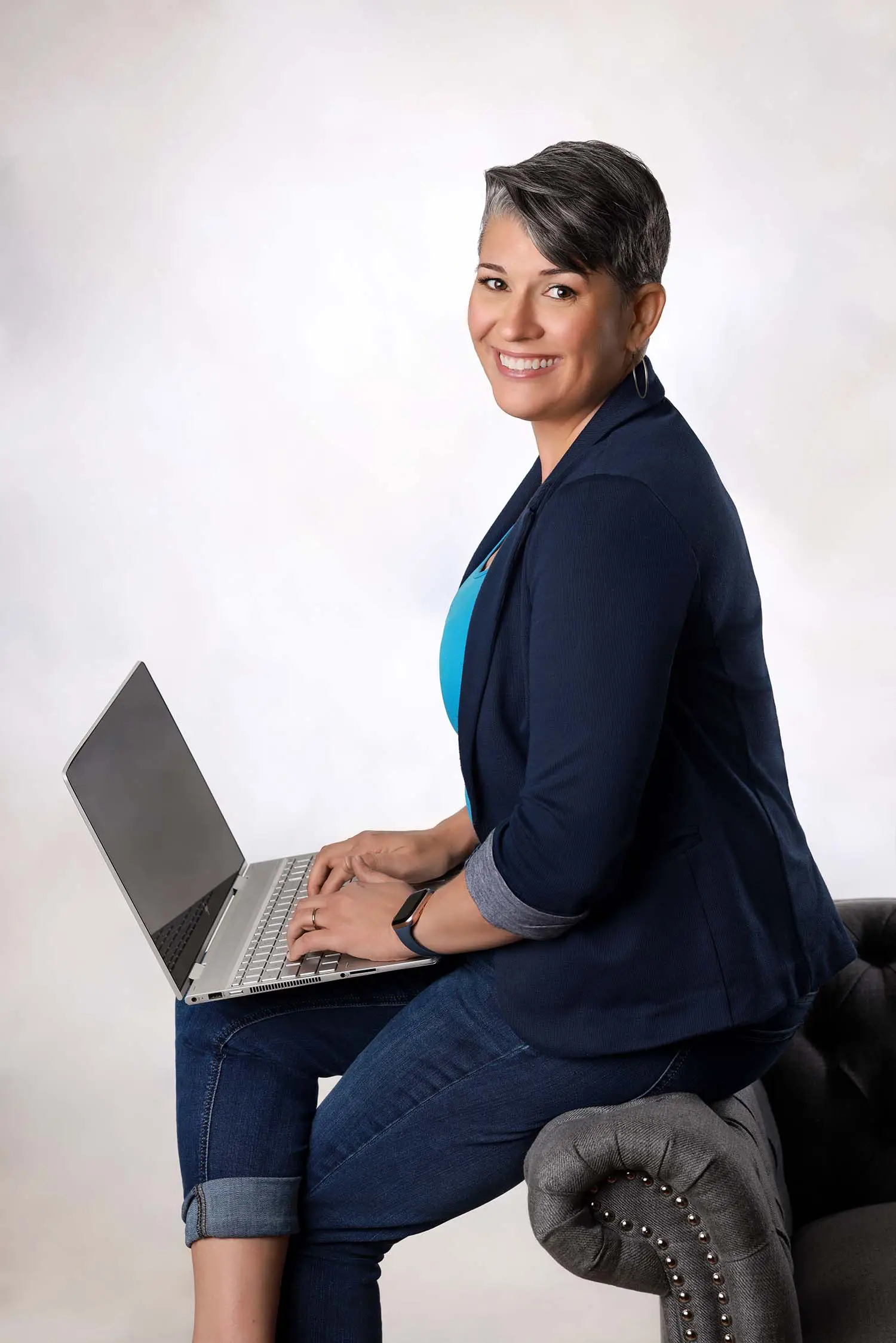 Andrea Goulet, communication coach, sitting with a laptop